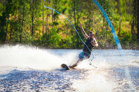Young man riding wakeboard on a summer lakeの写真素材