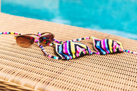 Sunglasses and colorul swimwear near swimming poolの写真素材