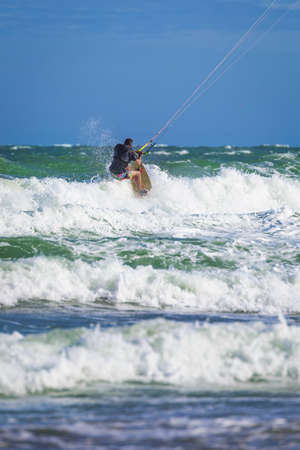 Athletic man riding on kite surf board on a sea wavesの写真素材