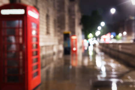 Popular red phone booth in night lights illumination blur unfocused in London, England, United Kingdomの写真素材