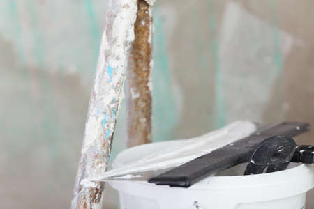 house improvement by worker puts finishing layer of stucco on the wall using a plastering trowelの写真素材