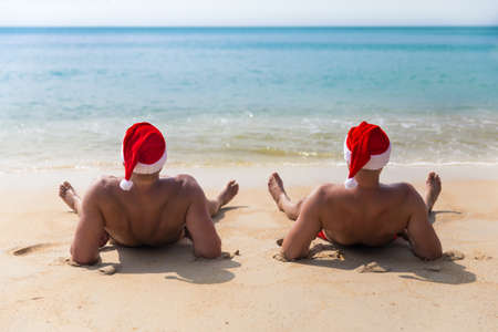 Man in Christmas red hat on a tropic sea beachの写真素材