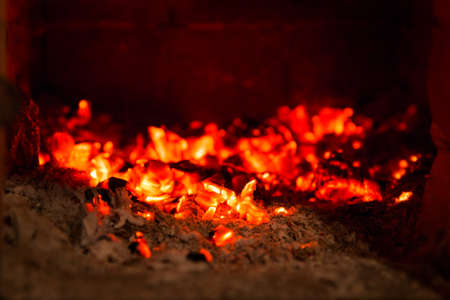 Fire flame coals in fireplace with ashesの写真素材