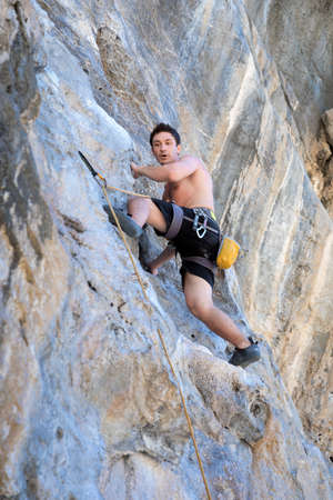 Young woman rock climbing on white mountain  in Thailandの写真素材