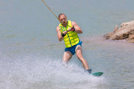 Man study wakeboarding on a blue lake summer sportsの写真素材