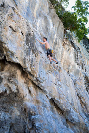 Young woman rock climbing on white mountain  in Thailandの写真素材