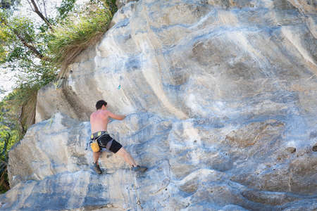 Young woman rock climbing on white mountain  in Thailandの写真素材