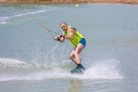 Man study wakeboarding on a blue lake summer sportsの写真素材