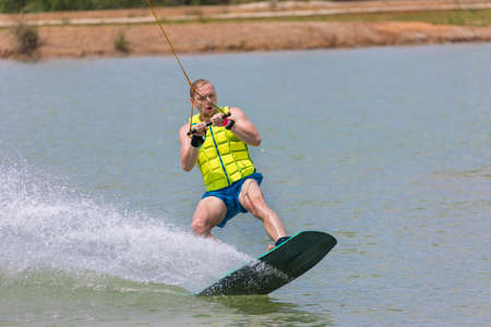 Man study wakeboarding on a blue lake summer sportsの写真素材