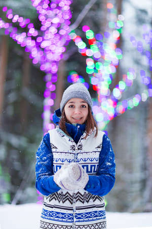 Happy winter women in park snow and Christmas lights