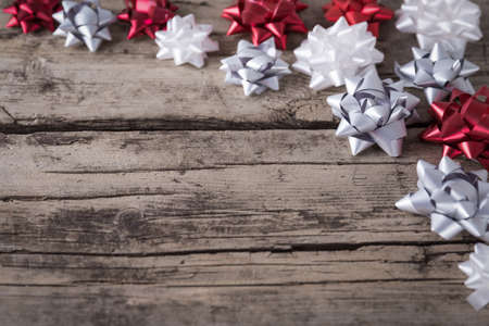 Silver white and red packaging bows on wooden background