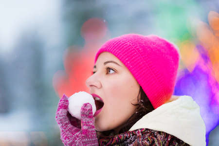 Happy winter women in park snow and Christmas lightsの写真素材