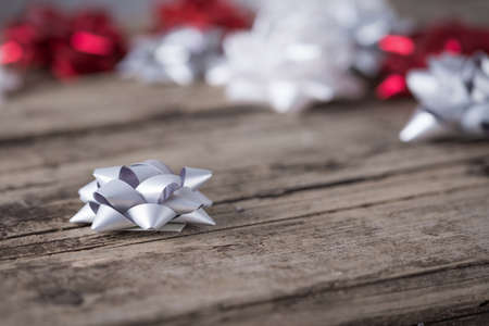 Silver white and red packaging bows on wooden backgroundの写真素材