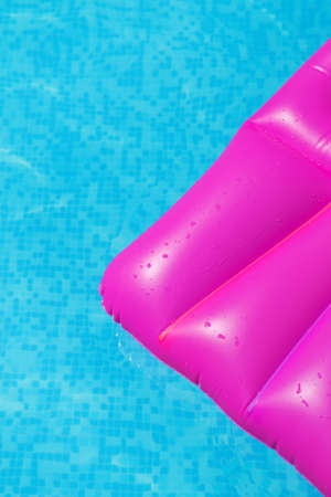 Pink air mattress on a swimming pool - holiday tropical background conceptの写真素材