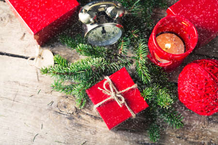 Red present box, candle and clock with snow Christmas compositionの写真素材