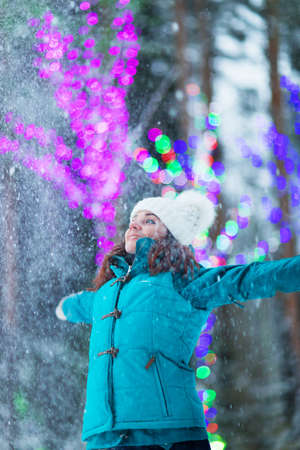 Happy winter women in park snow and Christmas lightsの写真素材