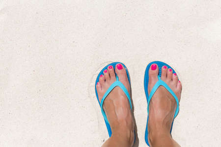 Woman's legs stand in sea water on the tropical beachの写真素材