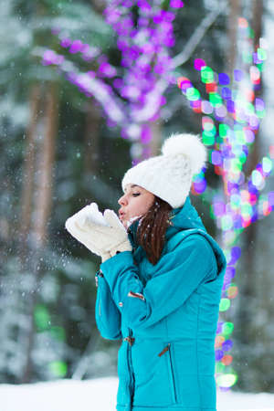 Happy winter women in park snow and Christmas lightsの写真素材