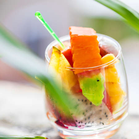 Glass of tropical exotic fruits salad outdoorsの写真素材