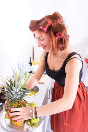 Young pretty woman housewife cooking with curlers on hairの写真素材