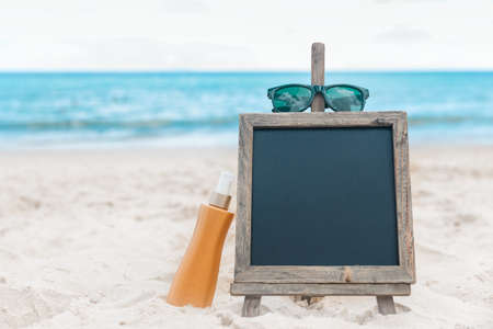 Chalk board with sunscreen cream in the sand on the beach tropic exotic backgroundの写真素材