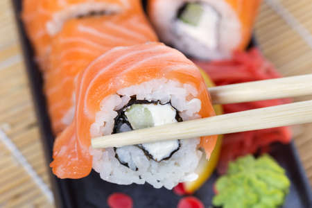 Salmon sushi rolls on a wooden backgroundの写真素材