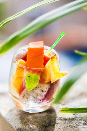 Glass of tropical exotic fruits salad outdoorsの写真素材