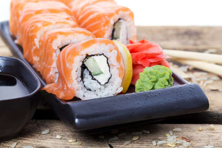 Salmon sushi rolls on a wooden table backgroundの写真素材