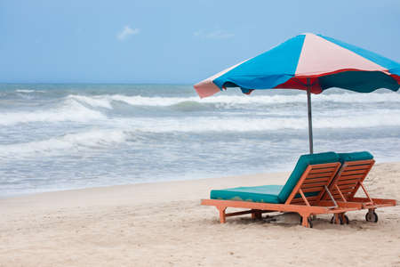 Summer beach sun chairs lounger sunbed near a perfect tropical sea