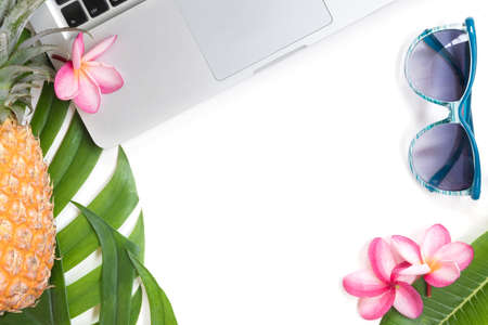 Tropical top view summer botanical concept still life laptop sunglasses pineapple frame with monstera liana, vine, palm leaves and plumeria frangipani flower flat lay layoutの写真素材