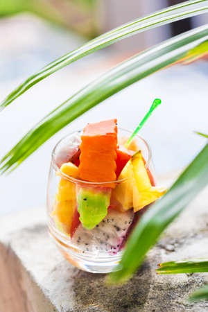 Glass of tropical exotic fruits salad outdoorsの写真素材