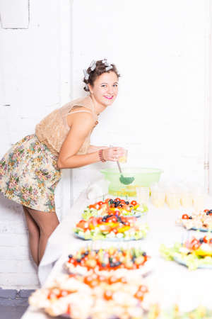 Young pretty woman housewife cooking with curlers on hairの写真素材