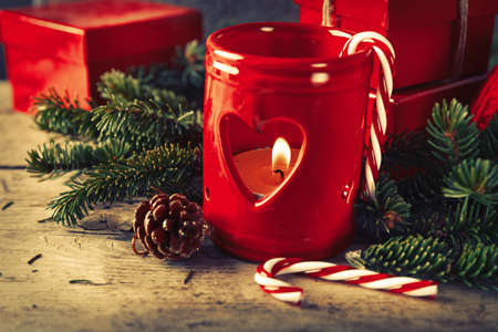 Red candle holder with present gifts boxes on wooden background Christmas New Year compositionの写真素材