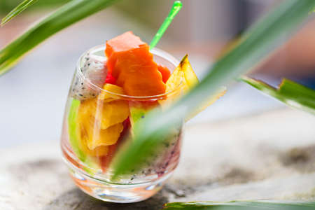 Glass of tropical exotic fruits salad outdoorsの写真素材