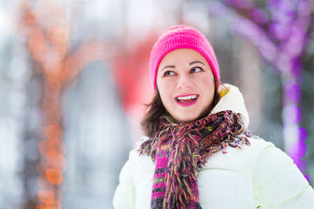 Happy winter women in park snow and Christmas lightsの写真素材