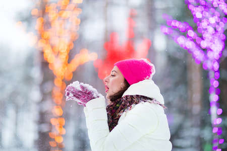 Happy winter women in park snow and Christmas lightsの写真素材