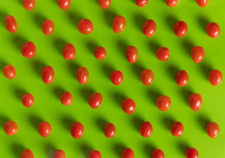 Tasty sweet ripe tomatoes pattern on a green backgroundの写真素材
