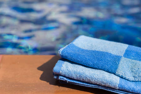 Fluffy blue towel on border of a swimming pool - holiday tropical conceptの写真素材