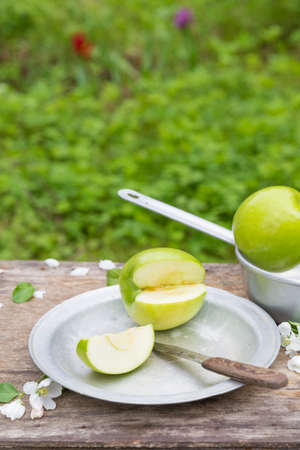 Fresh sweet juicy red and green apples with flowers on a woodenの写真素材