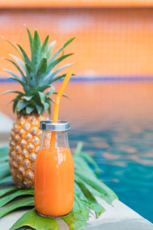 Fresh yellow pineapple tropic fruit summer refreshment smoothie shake drink near poolの写真素材