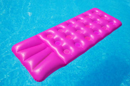 Pink air mattress on a swimming pool - holiday tropical background conceptの写真素材