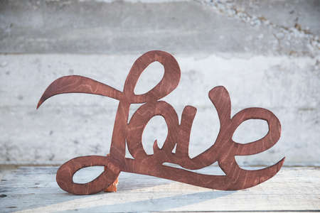 Wooden handwritten sign love on the concrete backgroundの写真素材