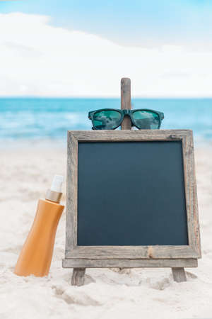 Chalk board with sunscreen cream in the sand on the beach tropic exotic backgroundの写真素材