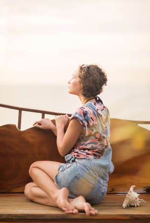 Young slim woman with seashell in handsの写真素材