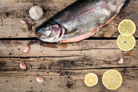 Fresh trout fish with spices on wooden backgroundの写真素材