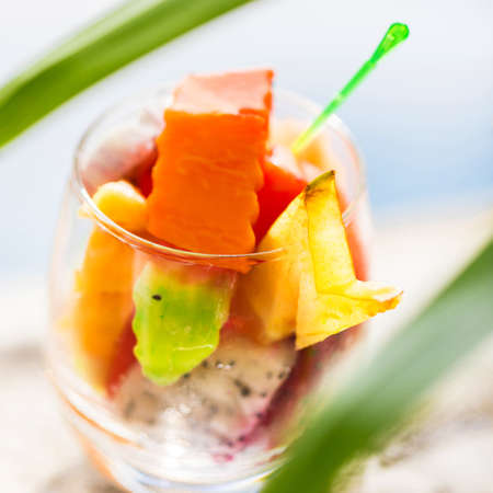 Glass of tropical exotic fruits salad outdoorsの写真素材