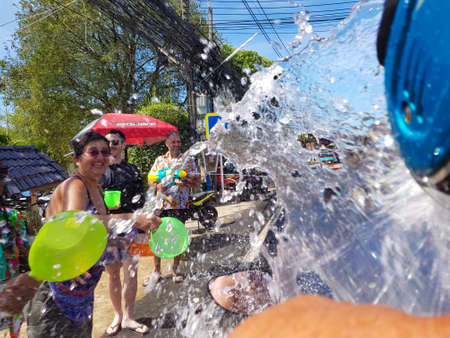 Phuket, Thailand - April 13, 2018: Crowd of people pour water on motorbike driver celebrate traditional Thai New Year - Songkran Festival, photo was taken on mobile phone Samsung Note 8のeditorial素材