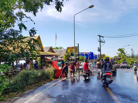 Phuket, Thailand - April 13, 2018: Man pour water on motorbike driver celebrate traditional Thai New Year - Songkran Festival, photo was taken on mobile phone Samsung Note 8のeditorial素材
