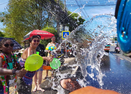 Phuket, Thailand - April 13, 2018: Crowd of people pour water on motorbike driver celebrate traditional Thai New Year - Songkran Festival, photo was taken on mobile phone Samsung Note 8のeditorial素材
