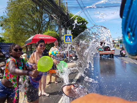 Phuket, Thailand - April 13, 2018: Crowd of people pour water on motorbike driver celebrate traditional Thai New Year - Songkran Festival, photo was taken on mobile phone Samsung Note 8のeditorial素材